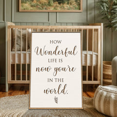 Framed print with 'How wonderful life is now you're in the world' text in a home setting.