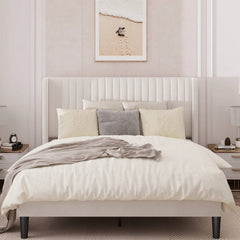 Neatly made bed with white bedding and decorative pillows in a bedroom setting.