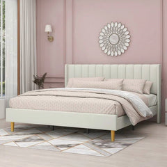 Light green upholstered bed with pink bedding in a room with pink walls and decorative elements.