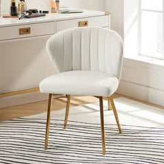 White chair with gold legs in a room with a desk and window.