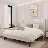 Neatly made bed in a modern bedroom with a window and framed picture on the wall.