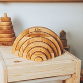 Set of wooden arch-shaped toys on a wooden surface with 'Elias' branding.