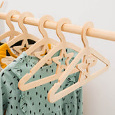 Wooden hangers with star designs on a rack with a green dress underneath.