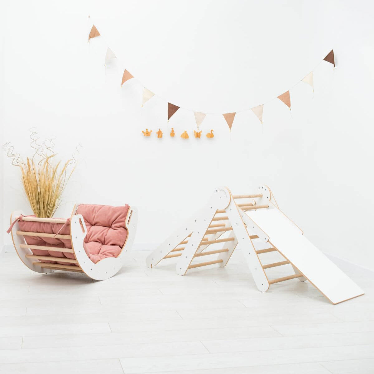 Children's play area with a pink chair and wooden slide on a white floor.