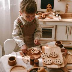 Child playing with wooden toys in a kitchen setting