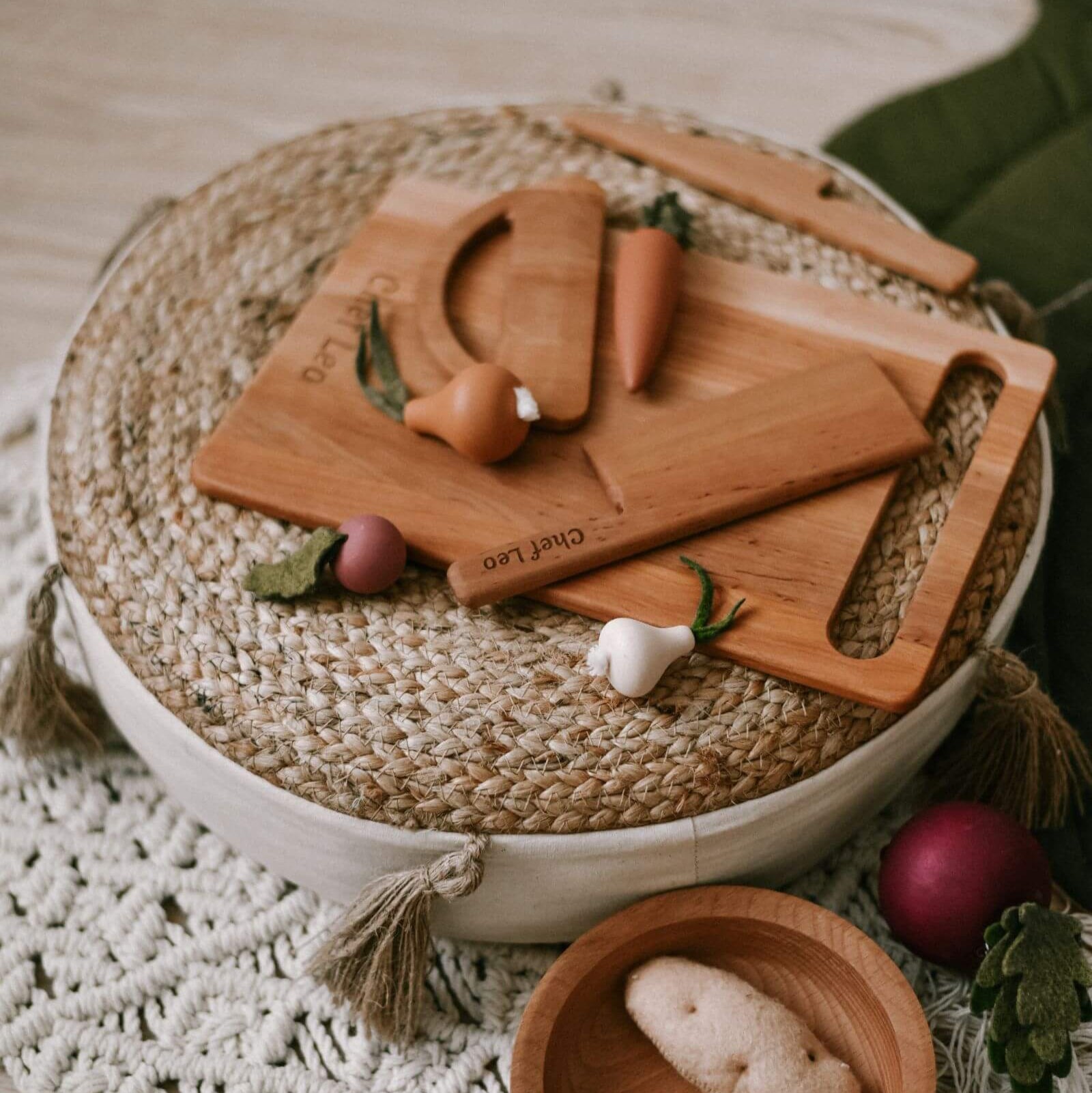 Set of wooden cutting boards with engraved vegetables on a woven mat