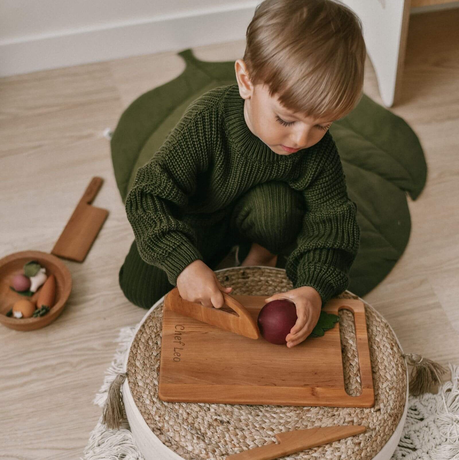 Child playing with wooden toys on a wooden floor