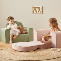 Two children sitting on a green chair and pink sofa with a teddy bear and books, surrounded by a cozy rug.