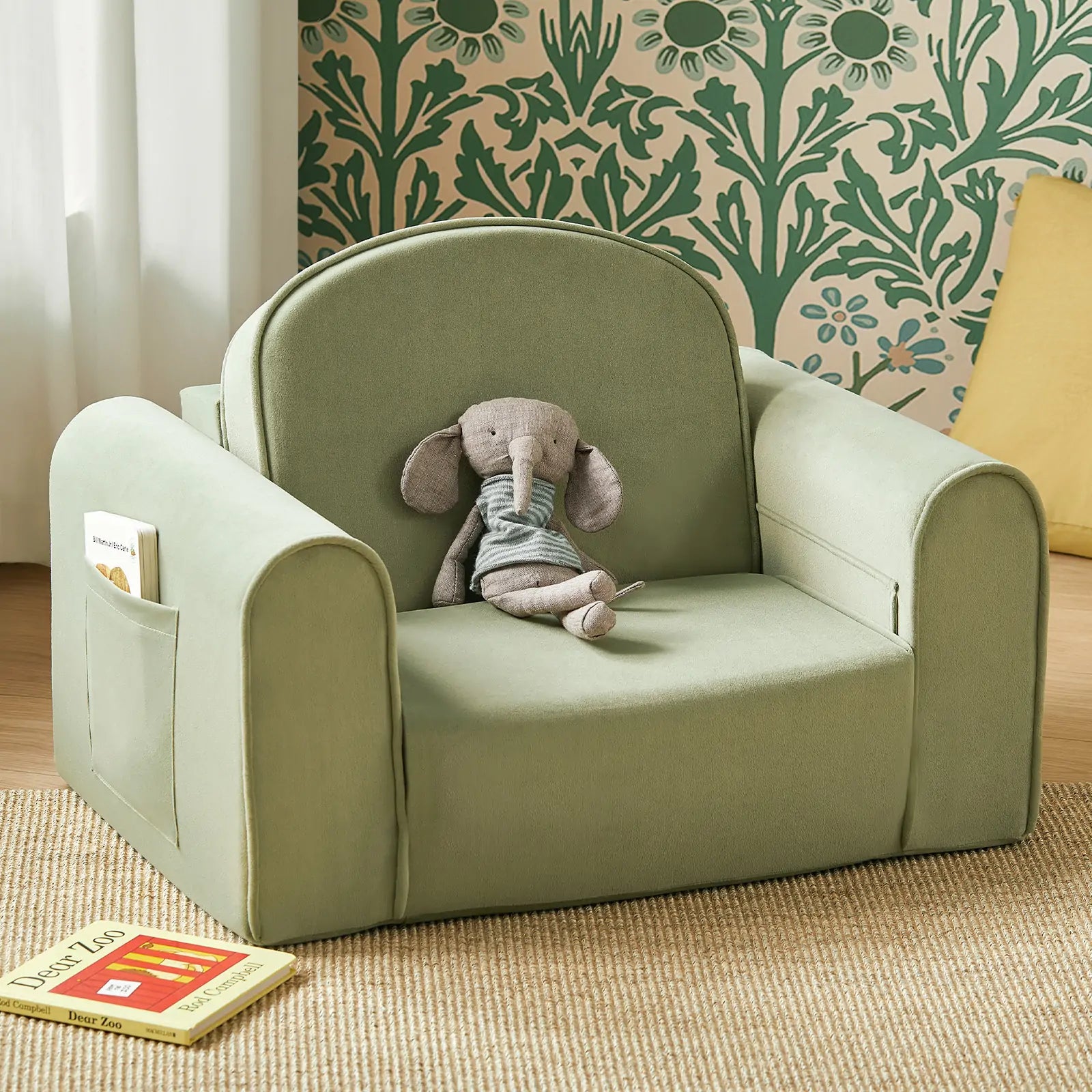 Children's green armchair with a stuffed elephant toy and a book on a beige carpet.