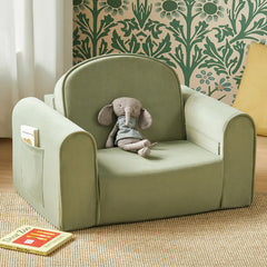 Children's green armchair with a stuffed elephant toy and a book on a beige carpet.
