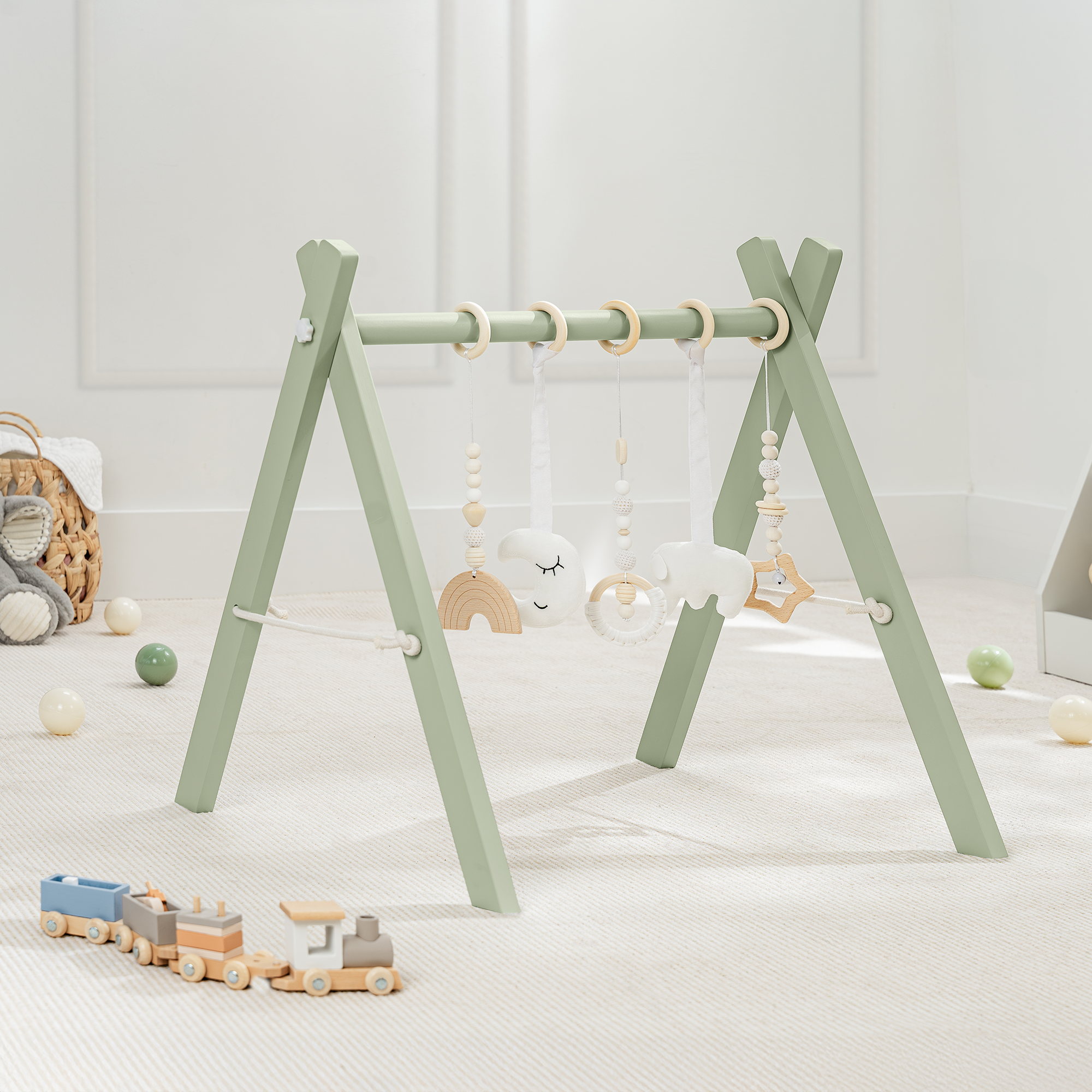 Children's play gym with hanging toys on a light wooden floor.