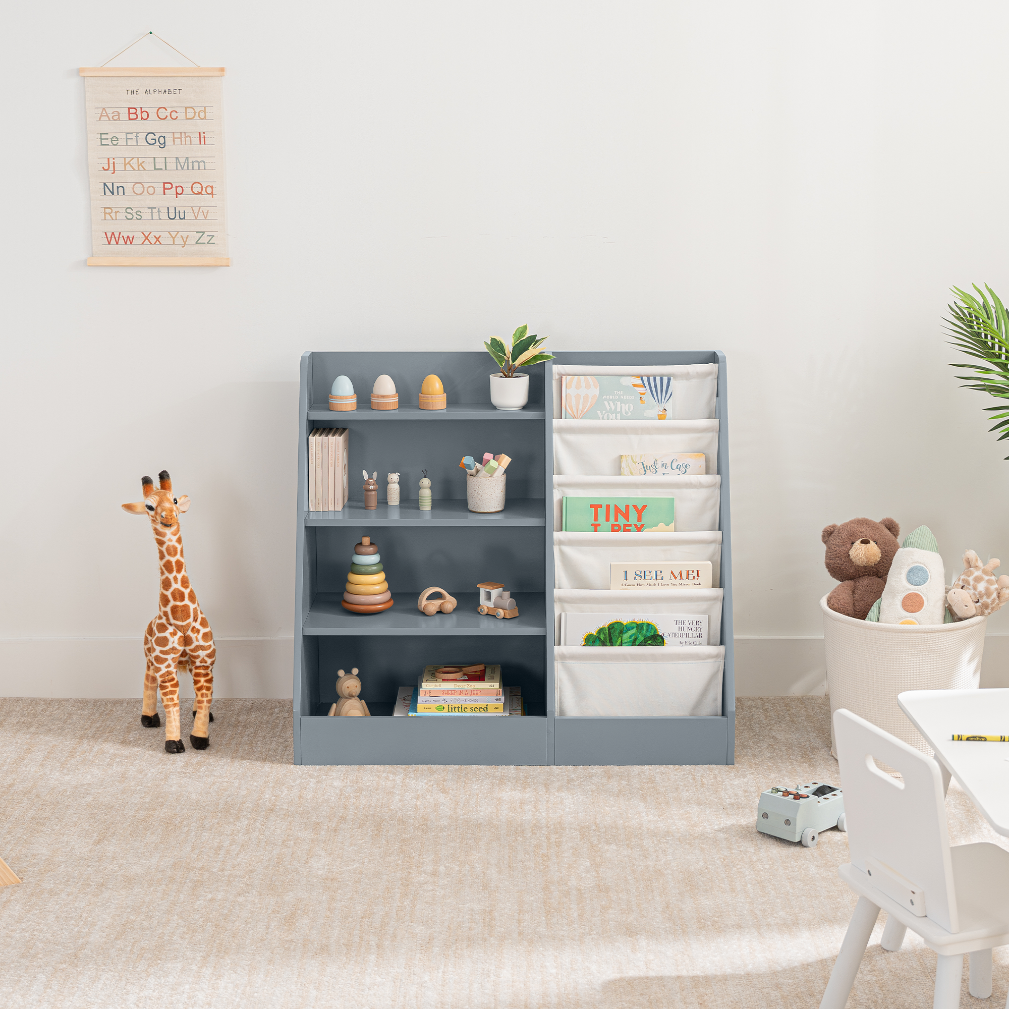 Blue kids bookshelf with open shelving and fabric compartments for books and toys in a playroom