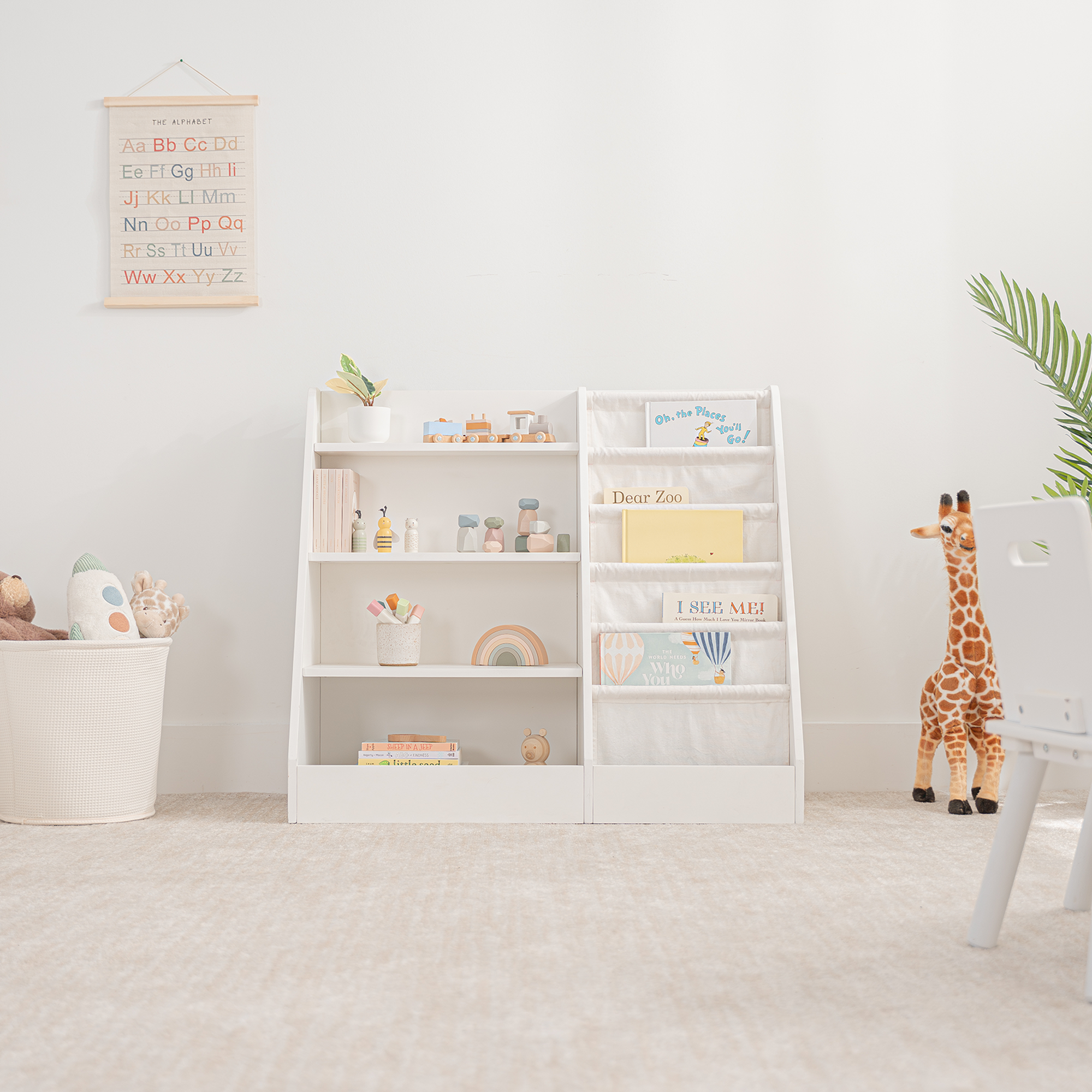 White kids bookshelf with open shelving and fabric compartments for books and toys in a playroom