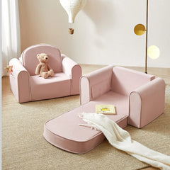 Pink children's chair and ottoman set with a teddy bear and blanket in a room.