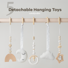 Detachable hanging toys with wooden and fabric elements on a rod against a light gray background.