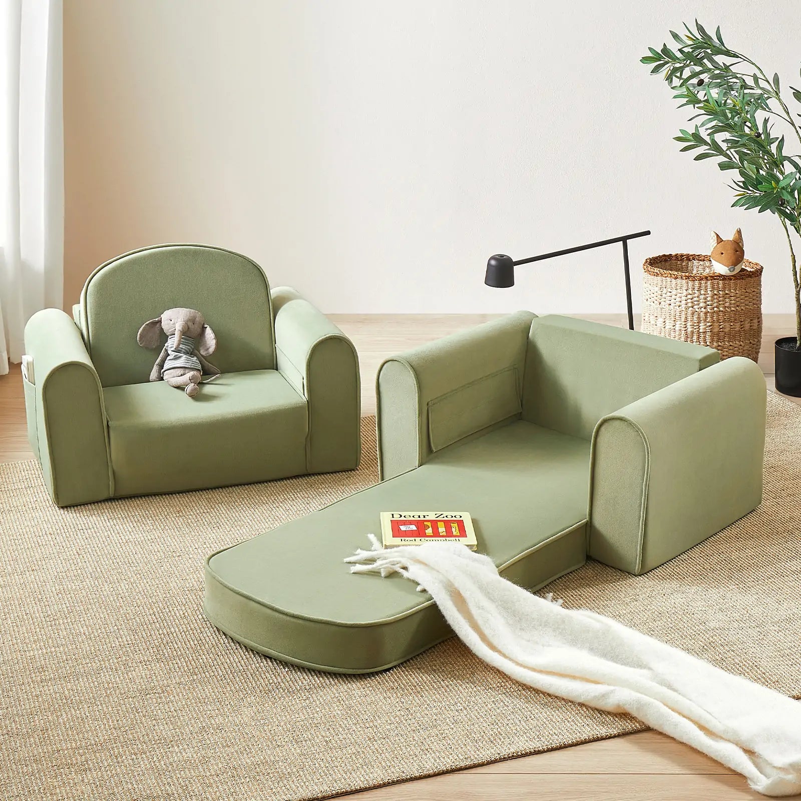 Green children's sofa and chair set on a wooden floor with a plant in the background.