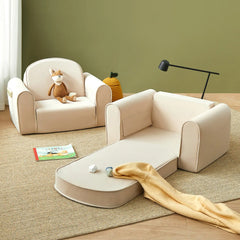 Children's beige sofa set with toys and a book on a wooden floor against a green wall.