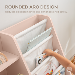 Close-up of blush kids bookshelf showing fabric storage bins and wooden shelf structure