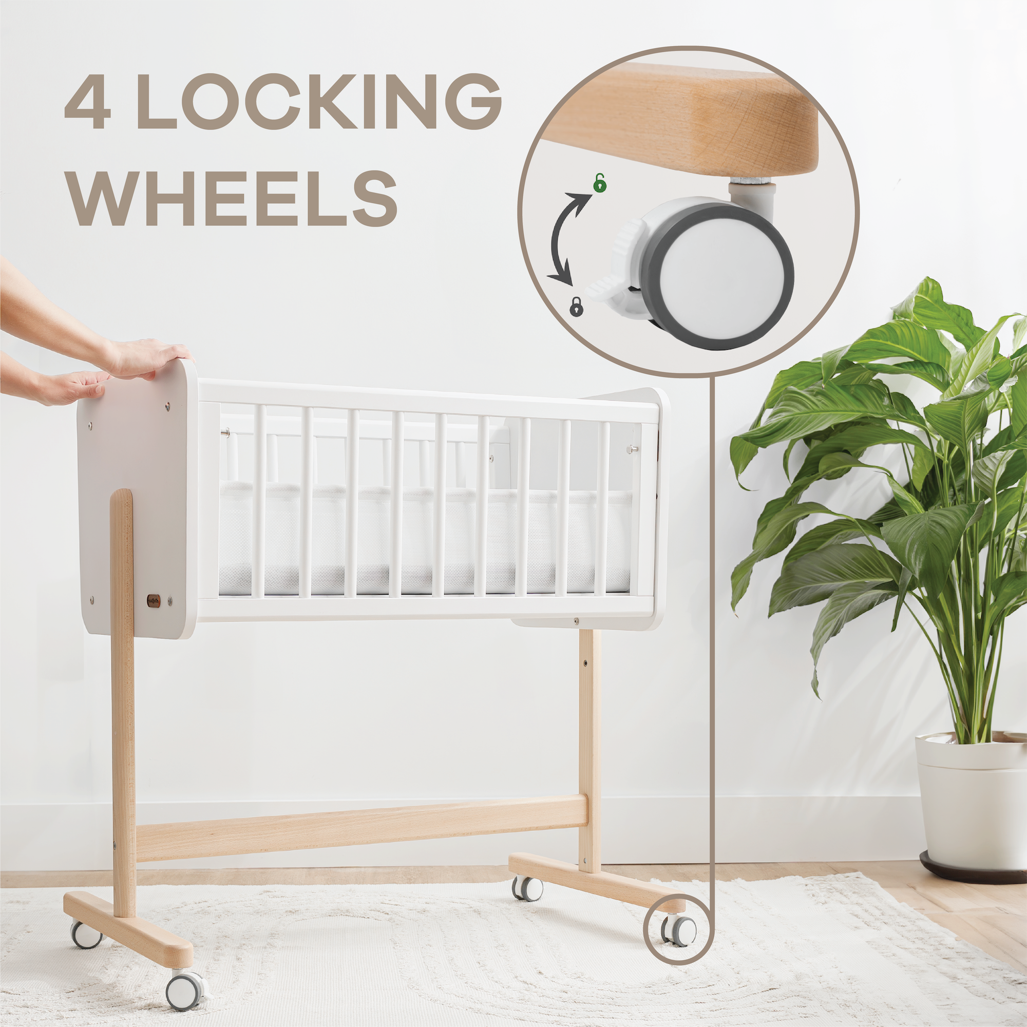 White crib with wooden frame on wheels, plant, and text '4 Locking Wheels' on a light background