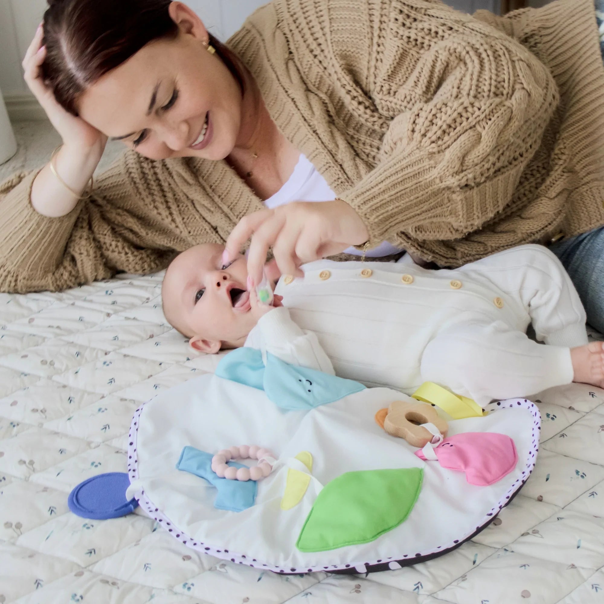 Parent and newborn using Montessori sensory set pieces during early development play