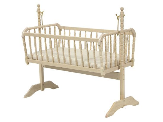Beige crib with a white mattress on a white background