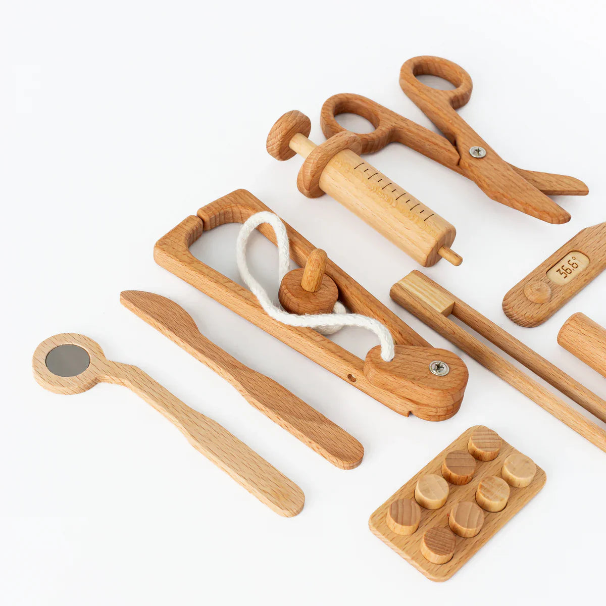 Set of wooden doctor tools including a thermometer, scissors, and stethoscope  on a white background