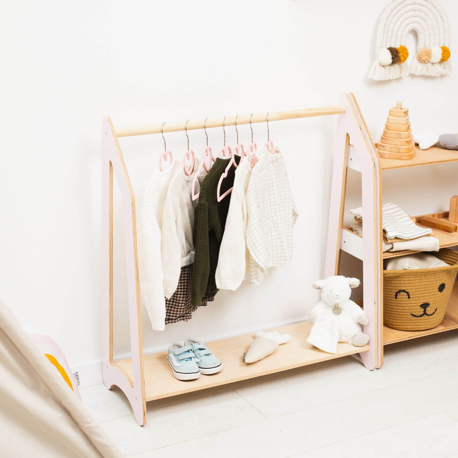 Children's wooden wardrobe with clothes, shoes, and toys on a white background