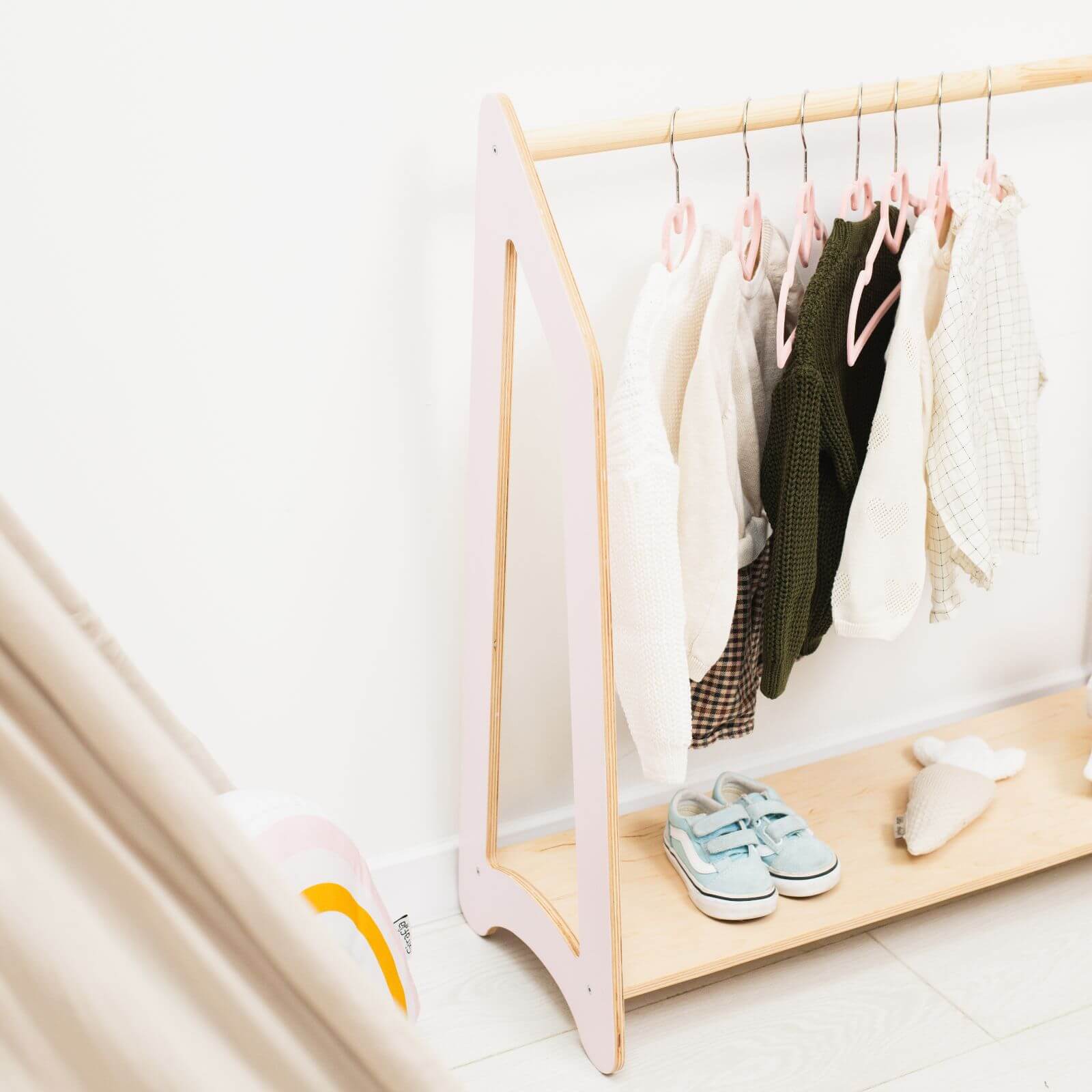 Children's clothing rack with clothes and shoes on a white background