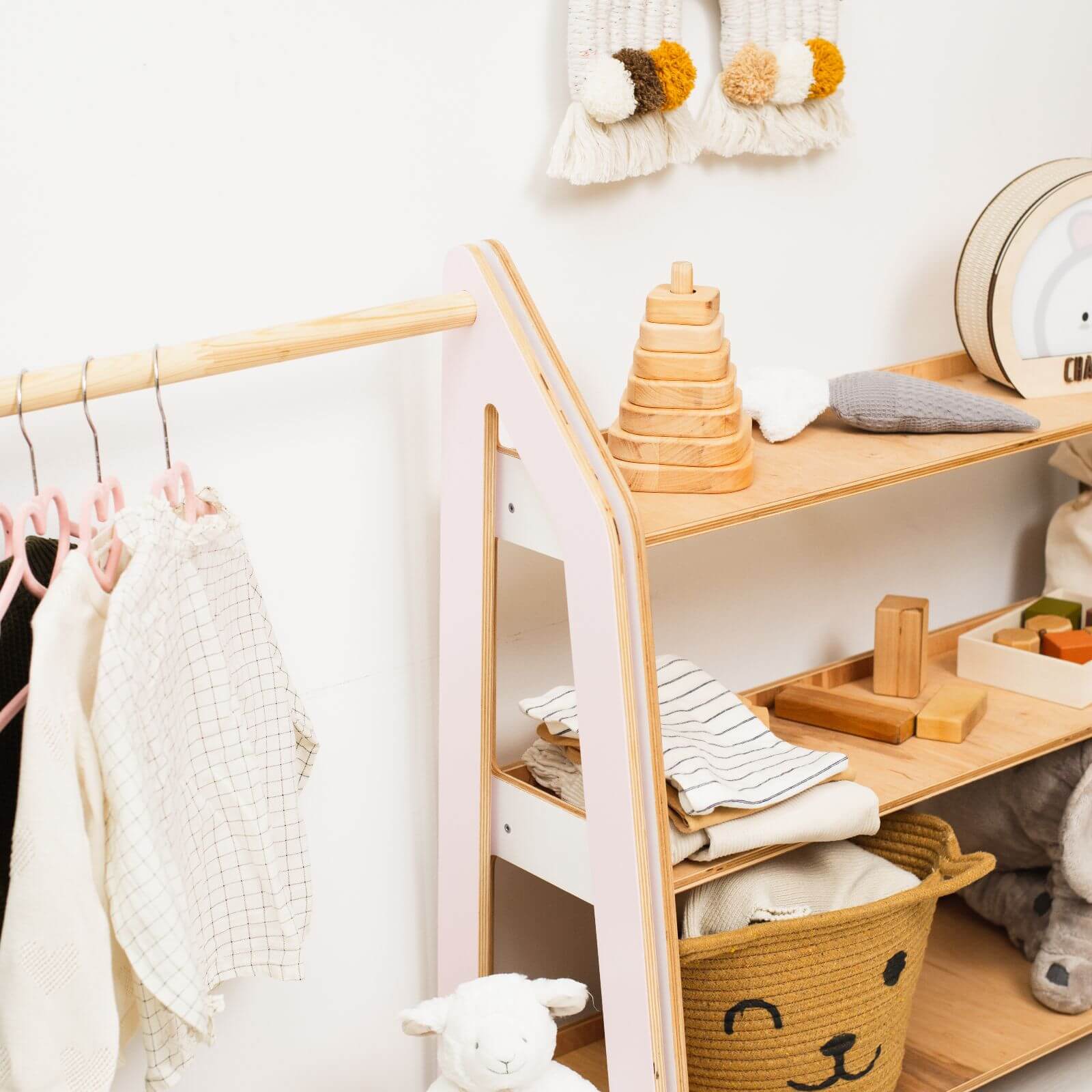 Children's room with wooden shelf, clothes rack, and toys.