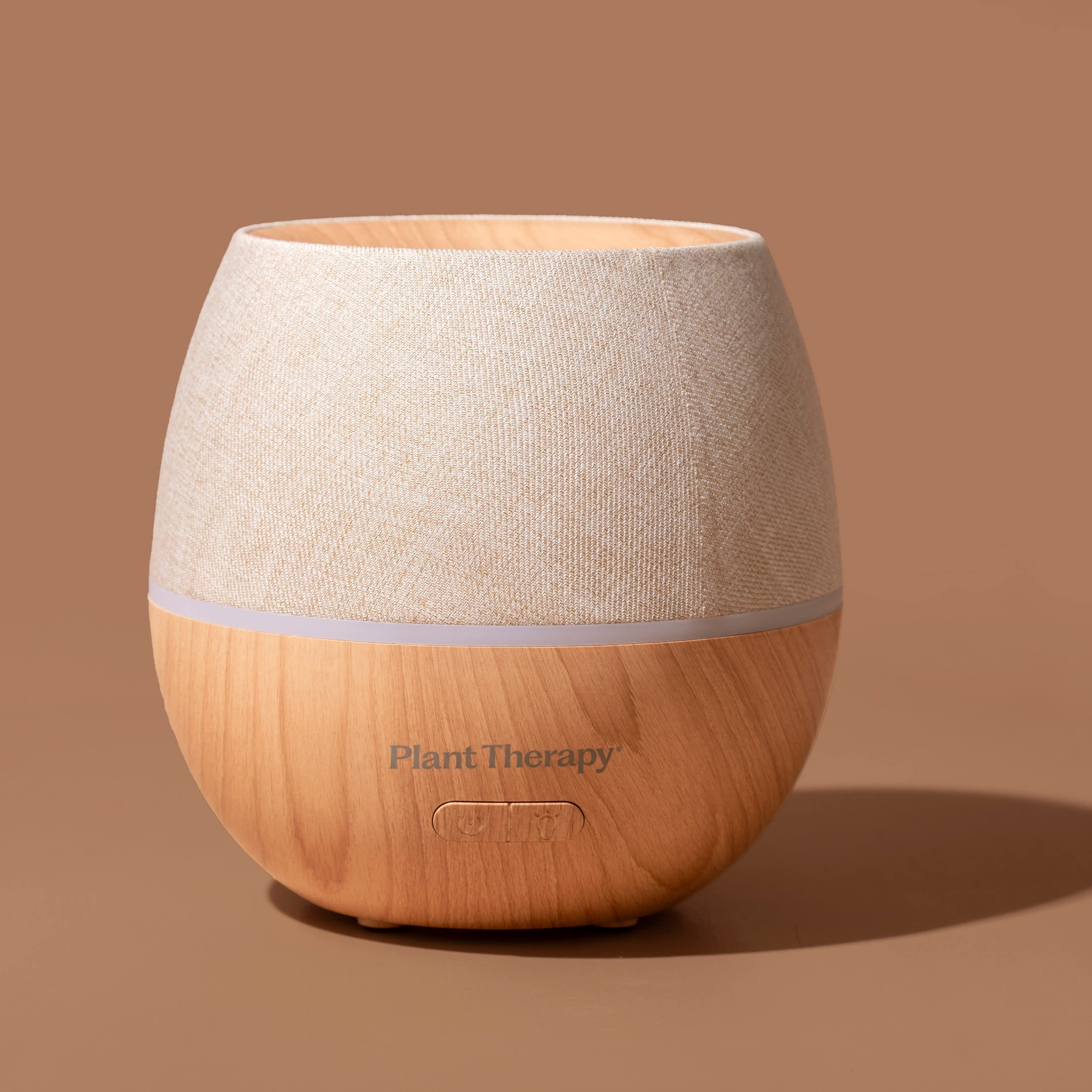 Wooden diffuser with textured beige top on a brown background