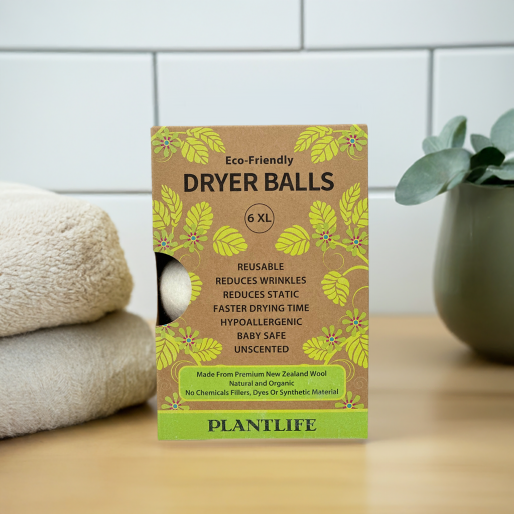 Box of Eco-Friendly Dryer Balls with green leaves on a wooden surface.