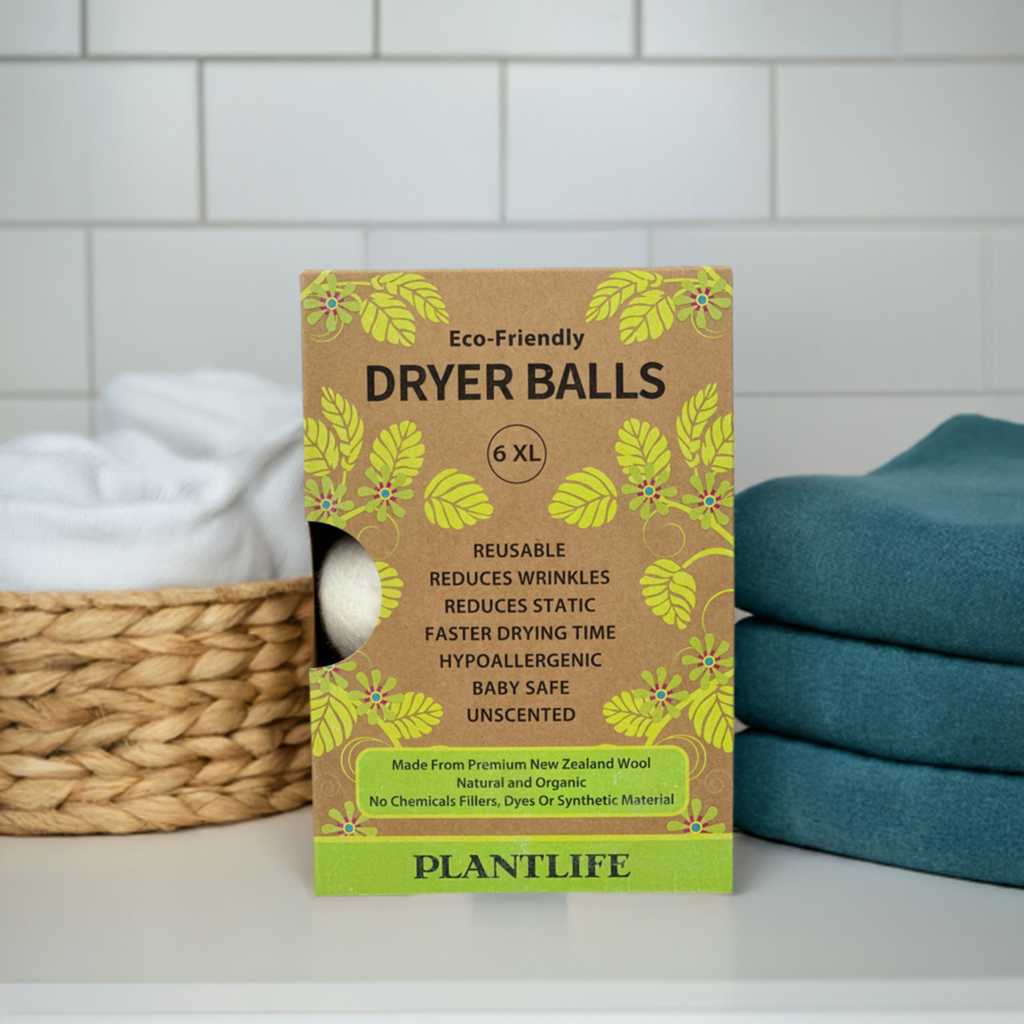 Box of Eco-Friendly Dryer Balls with a laundry basket and towels in the background