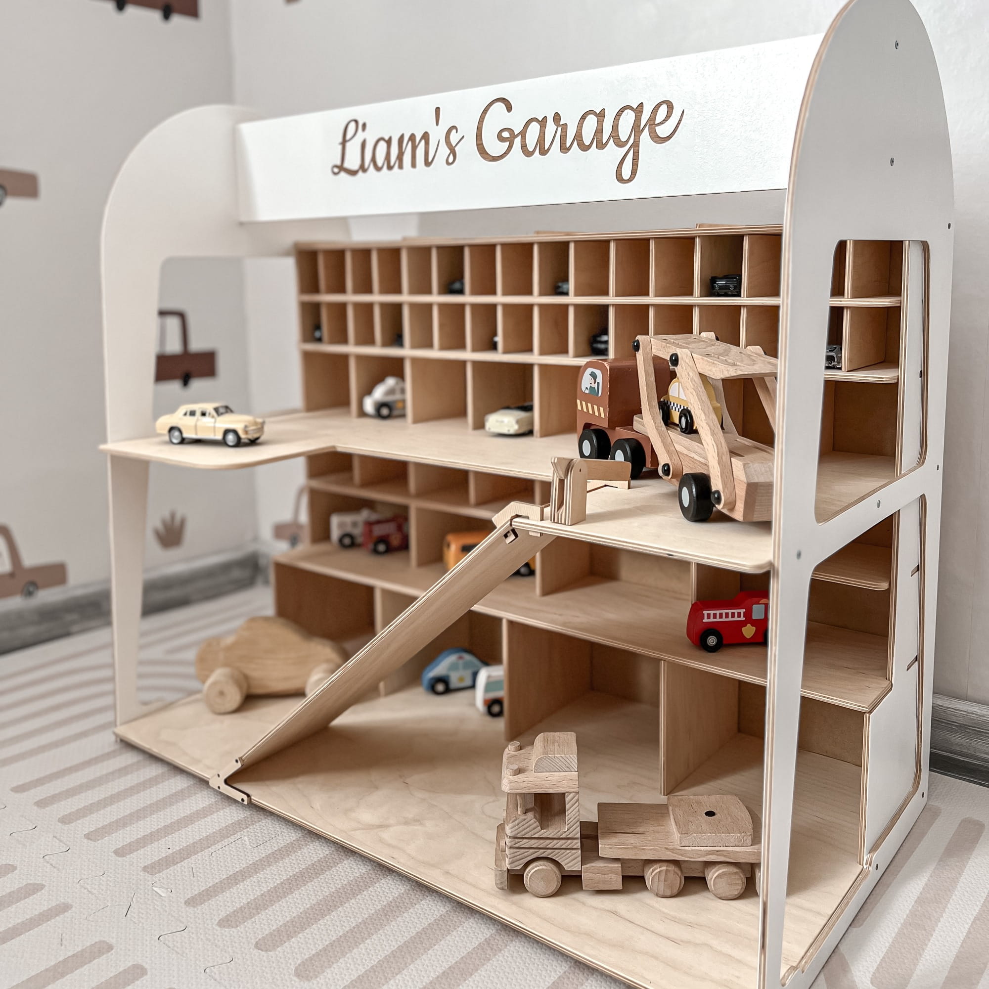 Wooden toy garage with shelves and toy cars, personalized with 'Liam's Garage'.