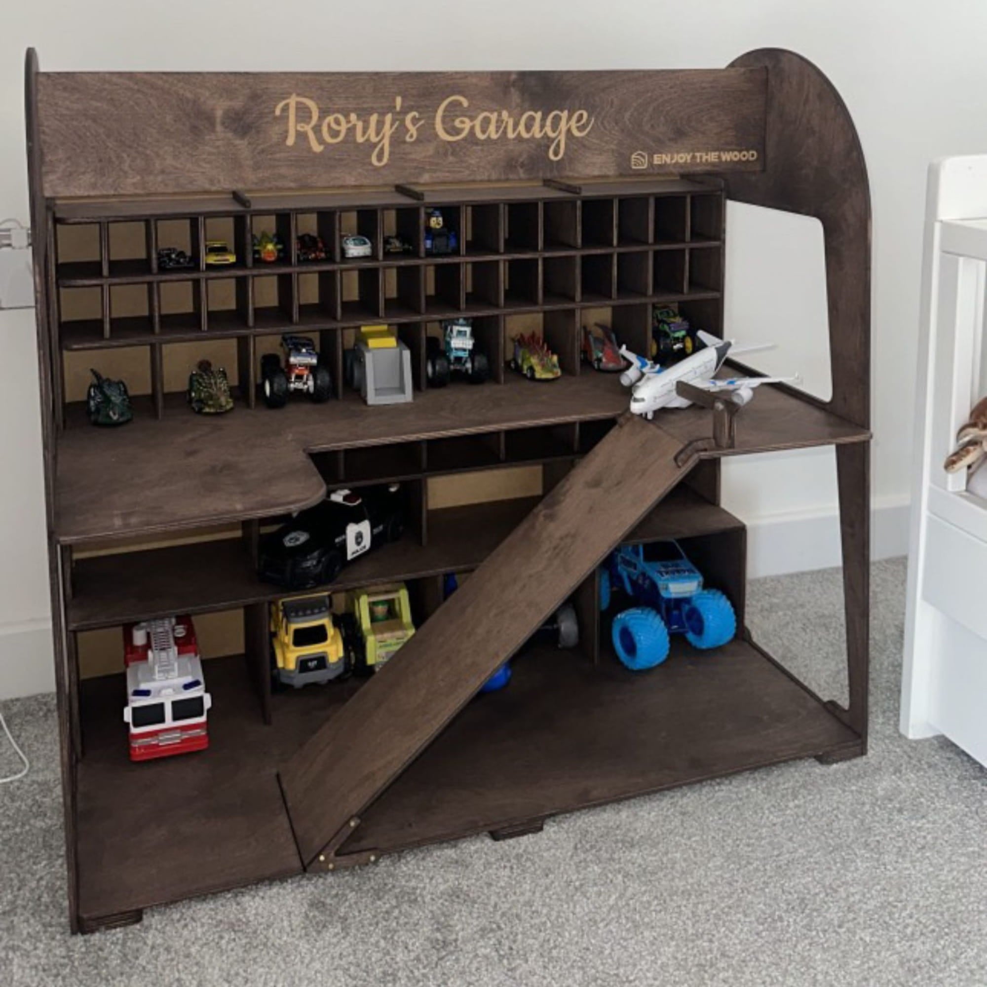 Wooden toy garage with shelves and a slide, personalized with 'Rory's Garage'.