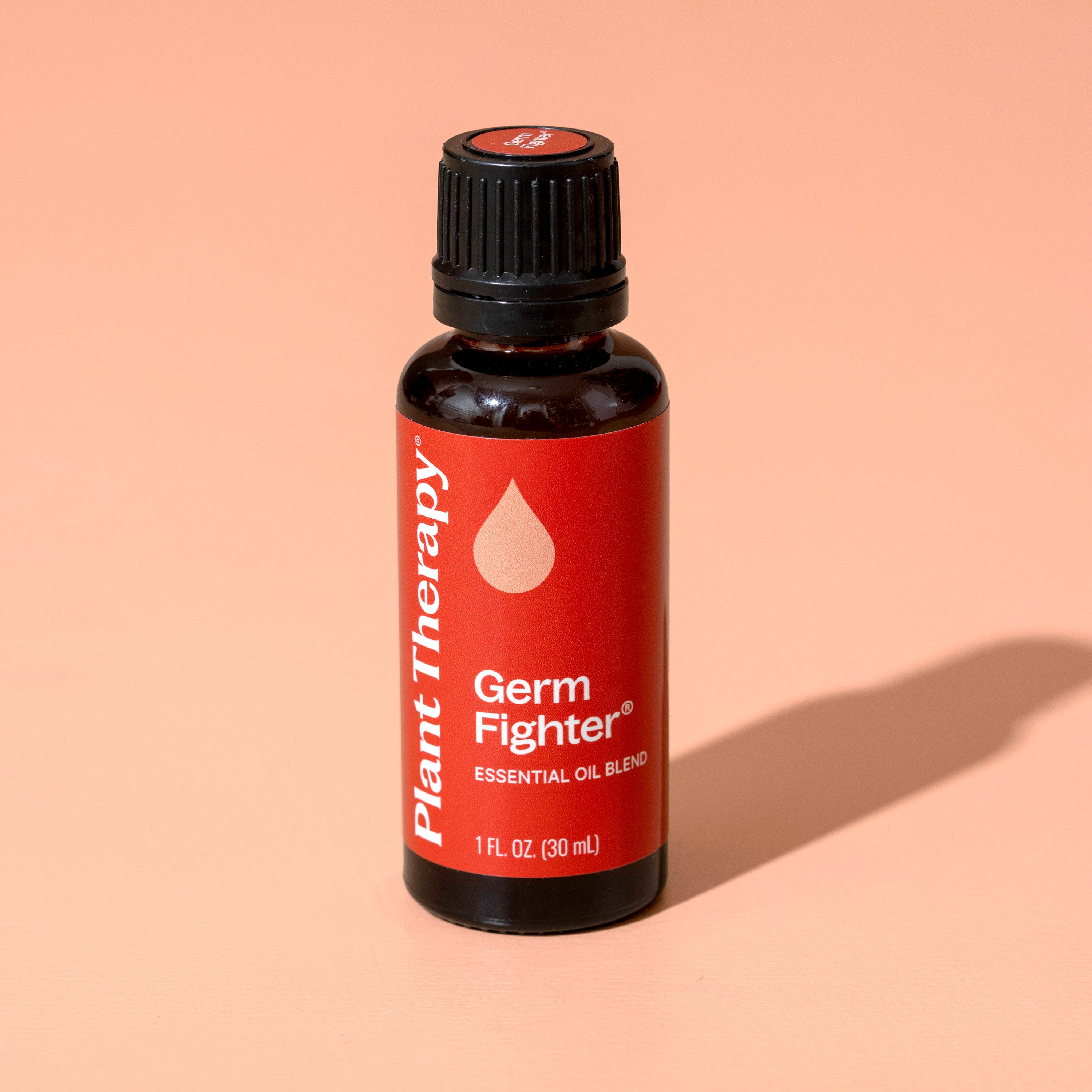 Bottle of Plant Therapy Germ Fighter essential oil blend on a peach background