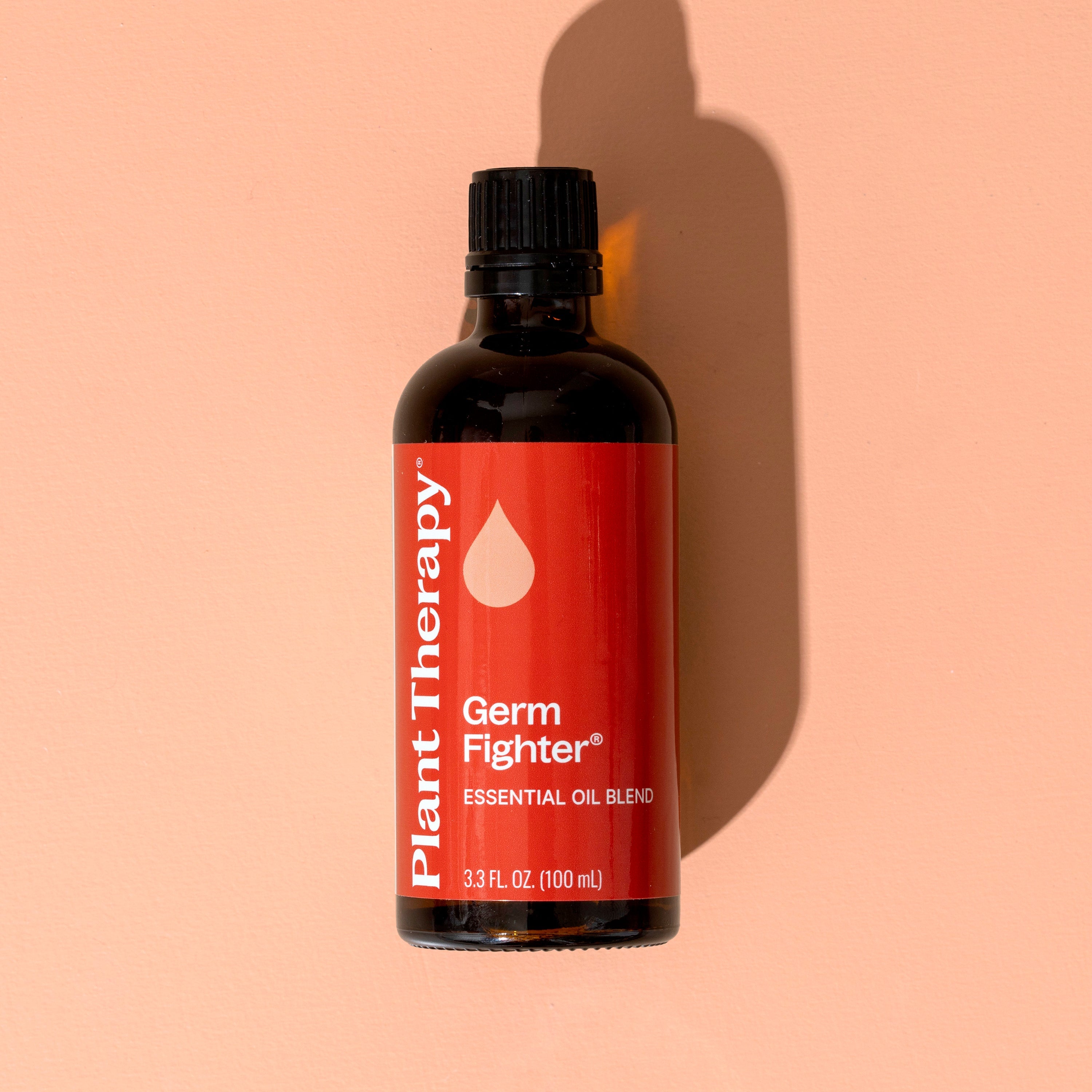 Bottle of Plant Therapy Germ Fighter essential oil blend on a peach background