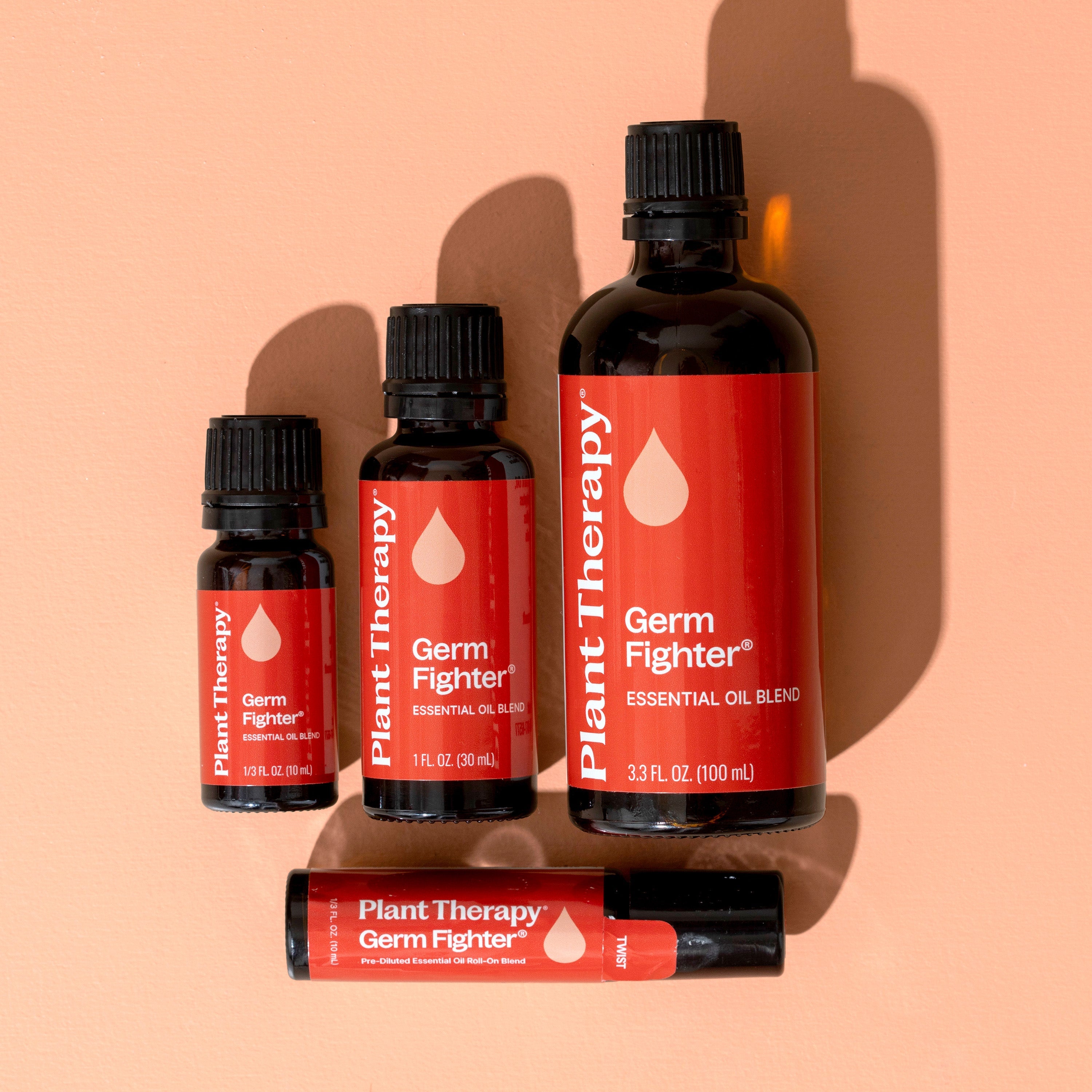 Collection of Plant Therapy Germ Fighter essential oil bottles on a peach background