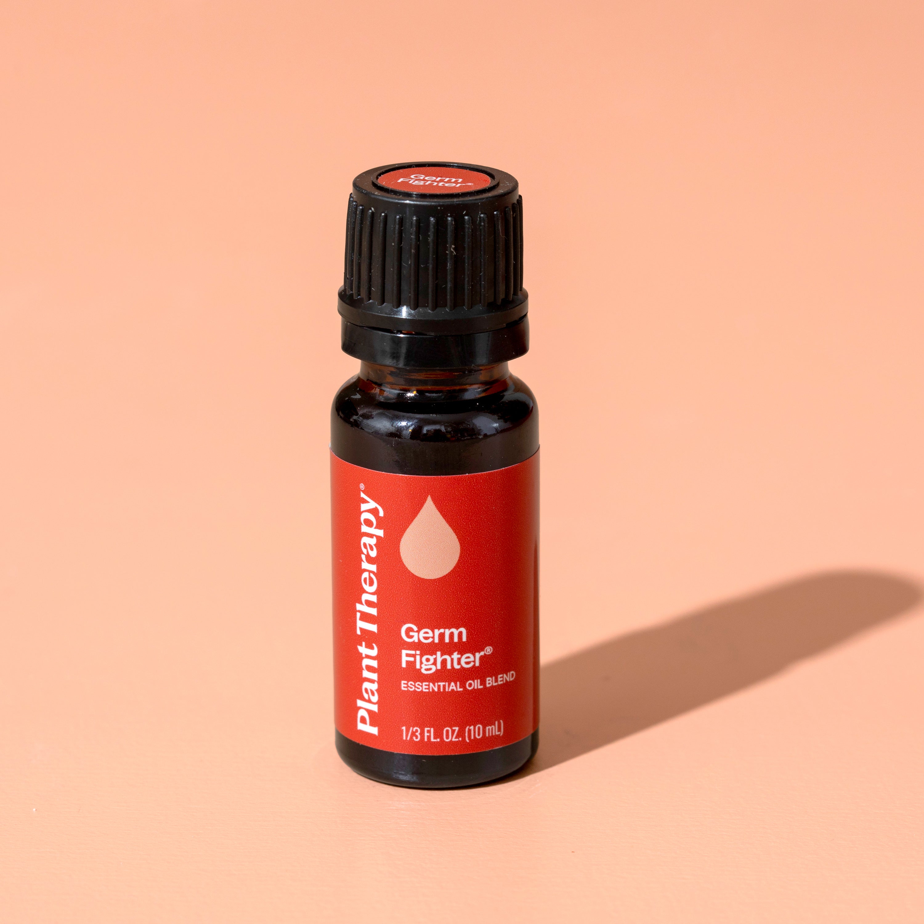 Essential oil bottle labeled 'Germ Fighter' by Plant Therapy on a peach background