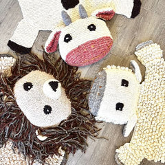 Three organic wool animal play mat designs displayed together — sheep, zebra, and polar bear