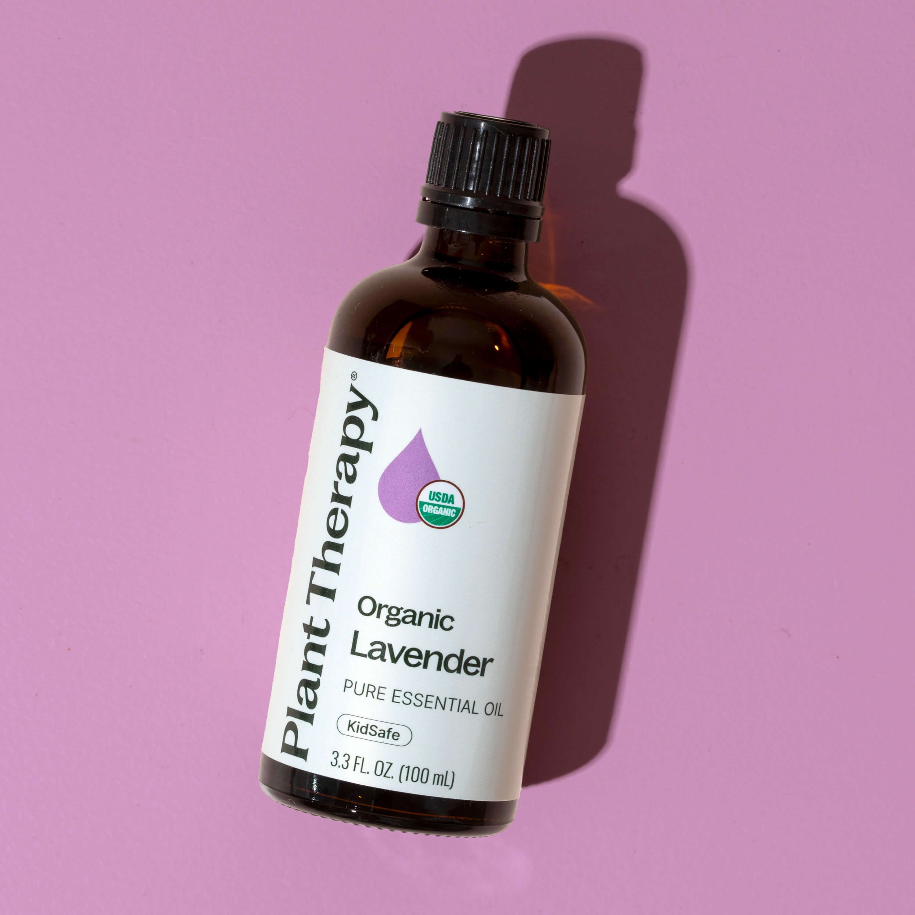 Bottle of Plant Therapy Organic Lavender essential oil on a pink background