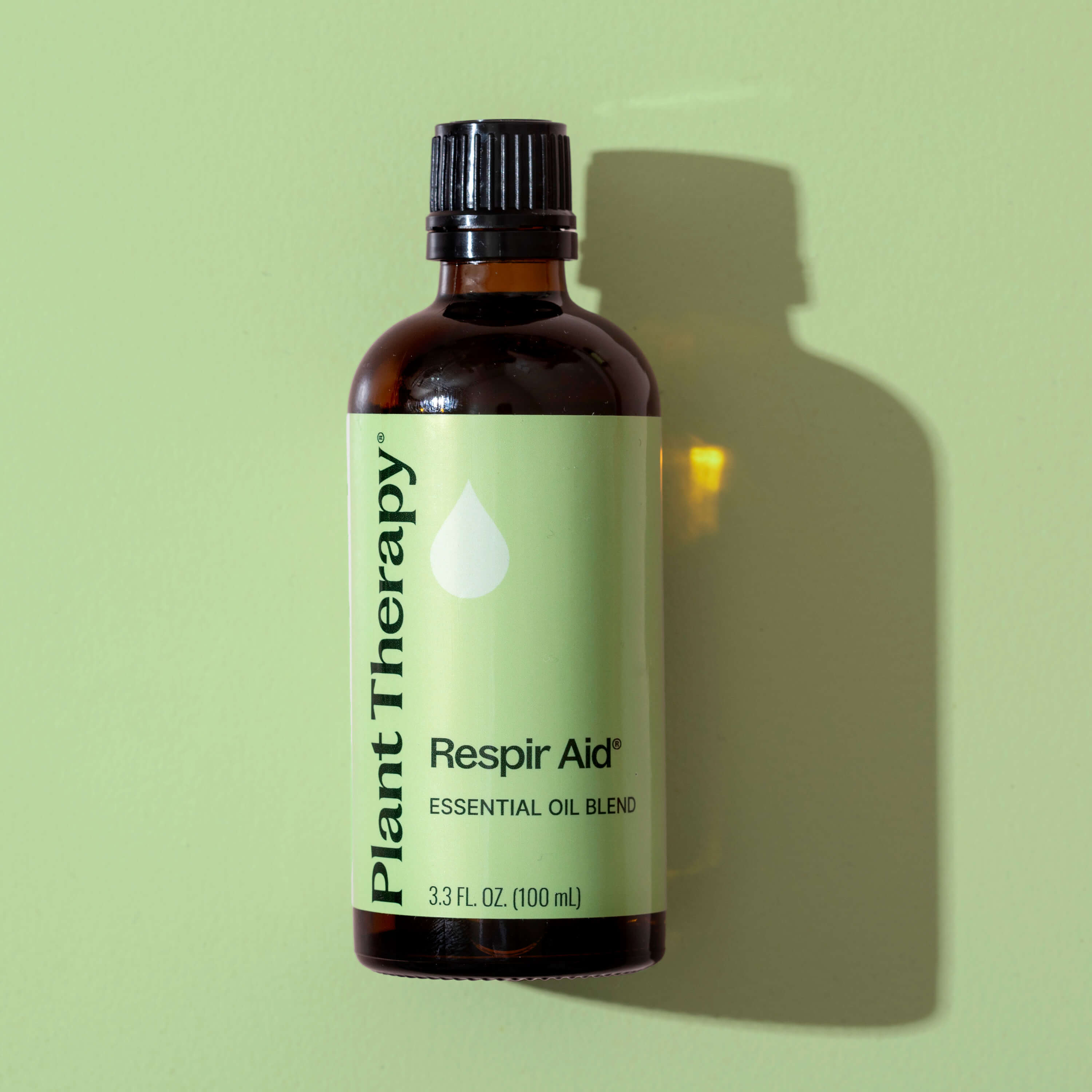 Bottle of Plant Therapy Respir Aid essential oil blend on a green background