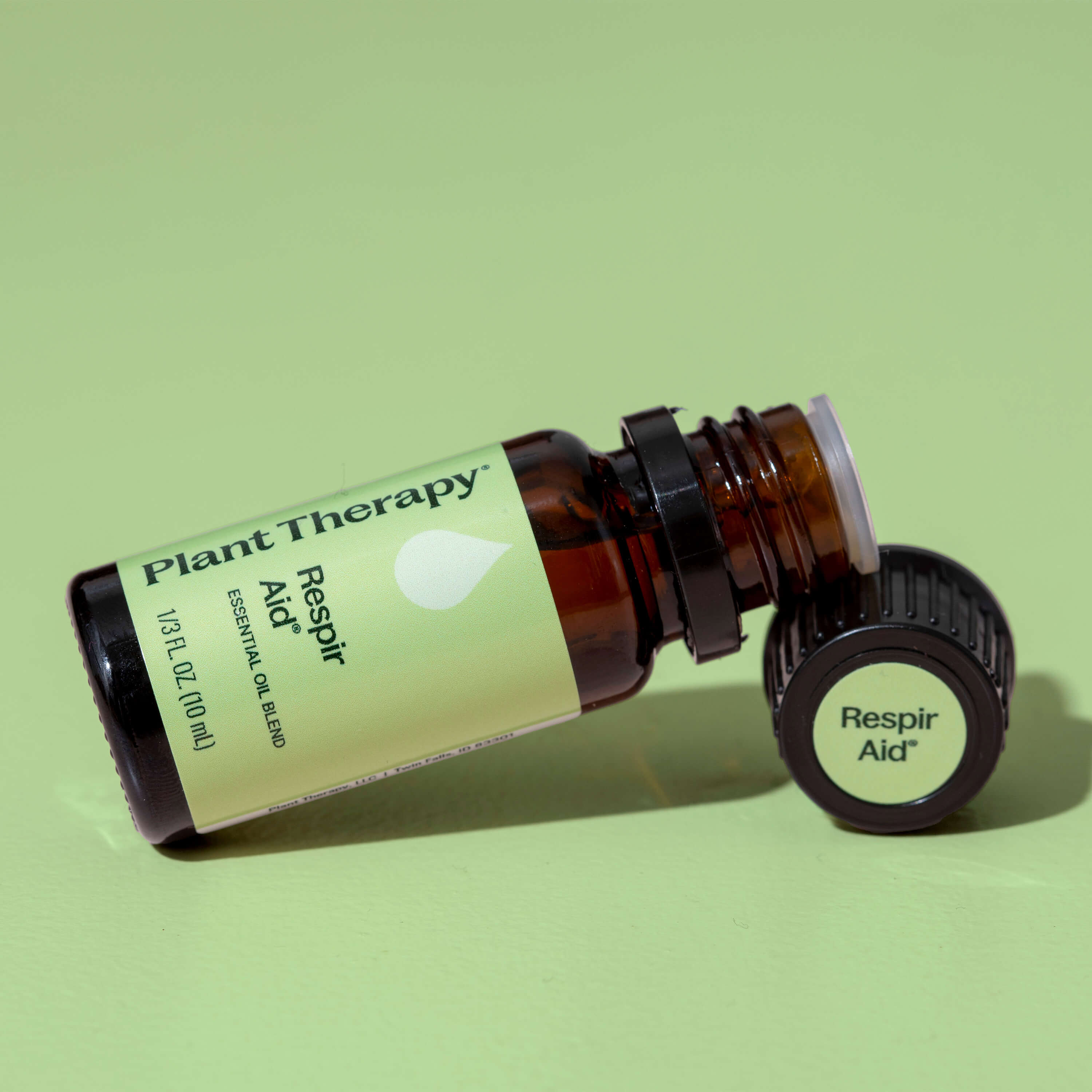 Plant Therapy Respiro Aid essential oil bottle on a green background