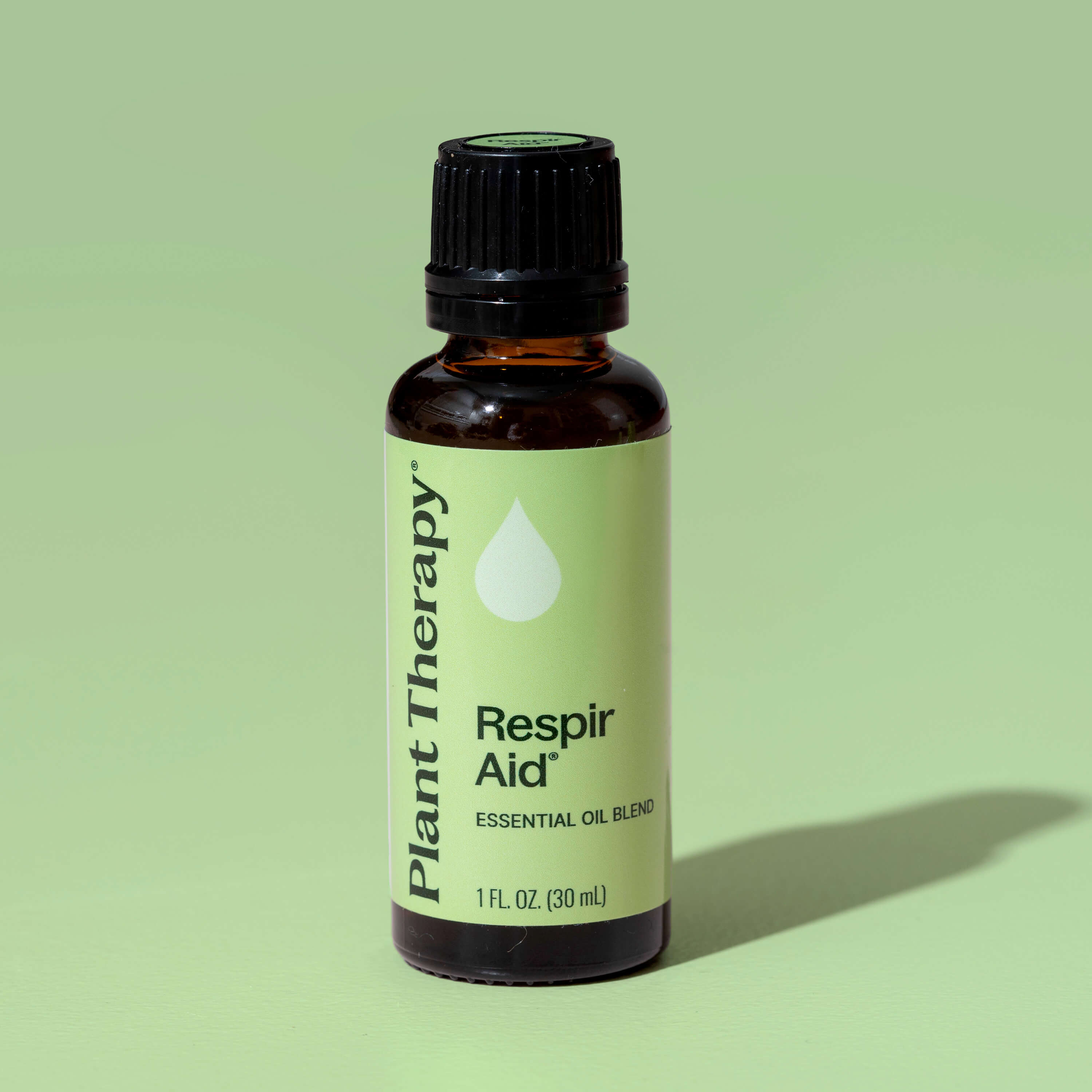 Bottle of Plant Therapy Respir Aid essential oil blend on a green background