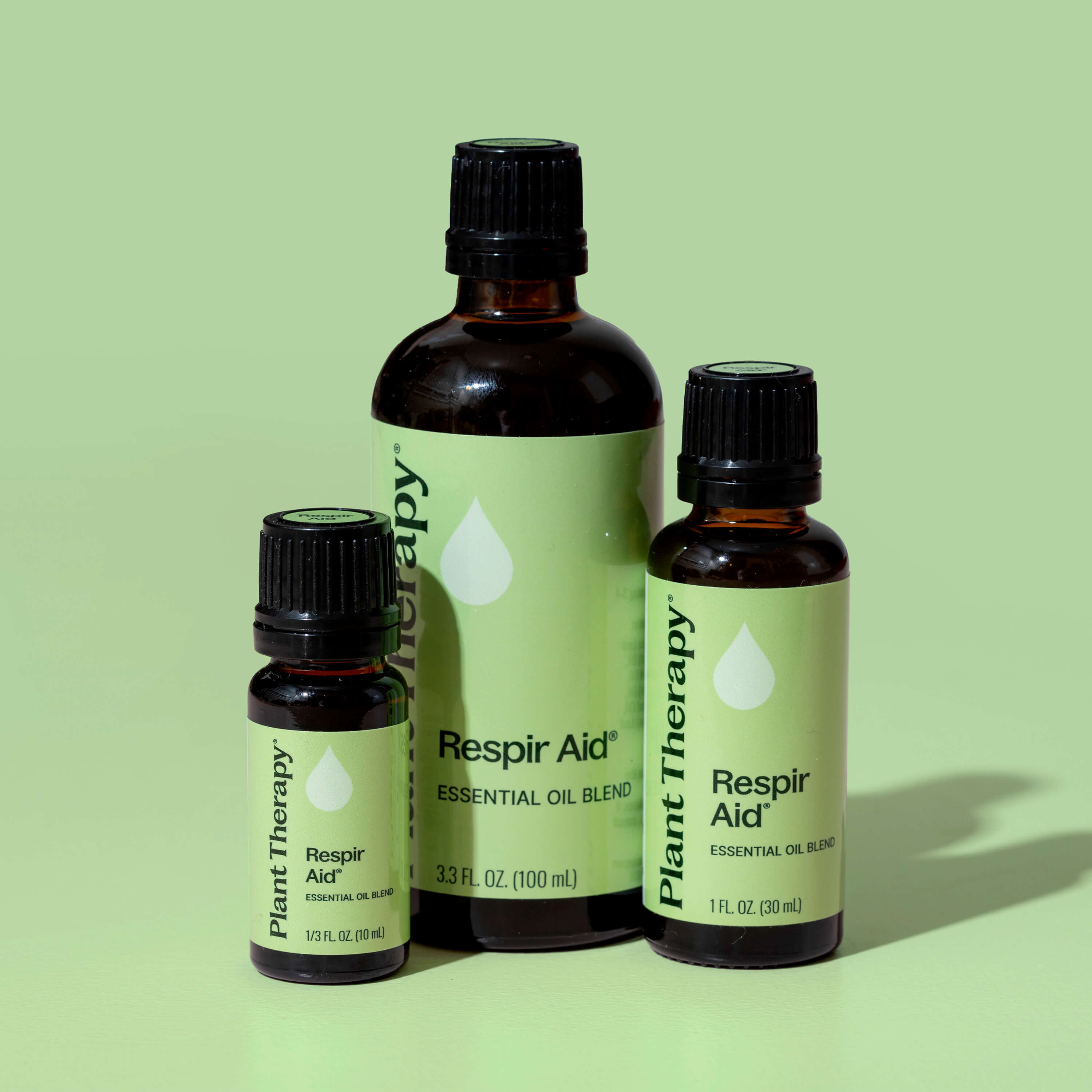 Three bottles of Plant Therapy Respiro Aid essential oil on a green background
