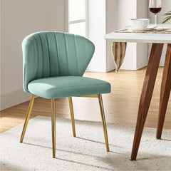 Teal chair with gold legs in a room with a table and wine glass.