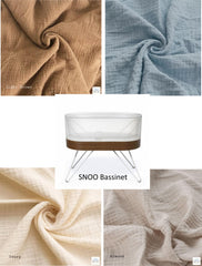 SNOO bassinet with fabric swatches labeled 'Light Brown', 'Blue', 'Ivory', and 'Almond' on a white background.