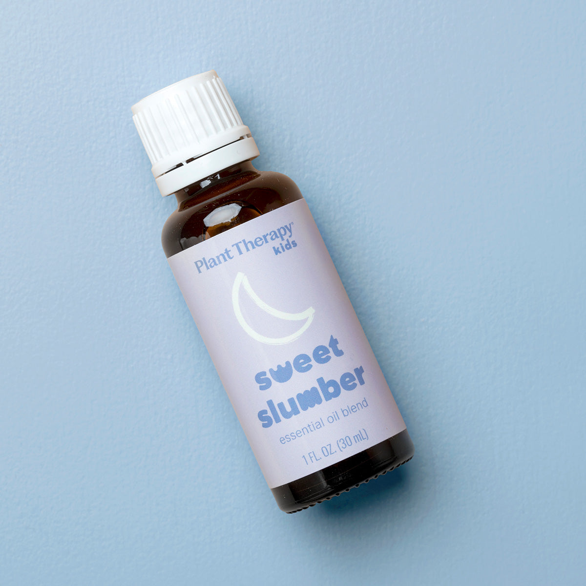 Bottle of Plant Therapy Kids Sweet Slumber essential oil blend on a light blue background