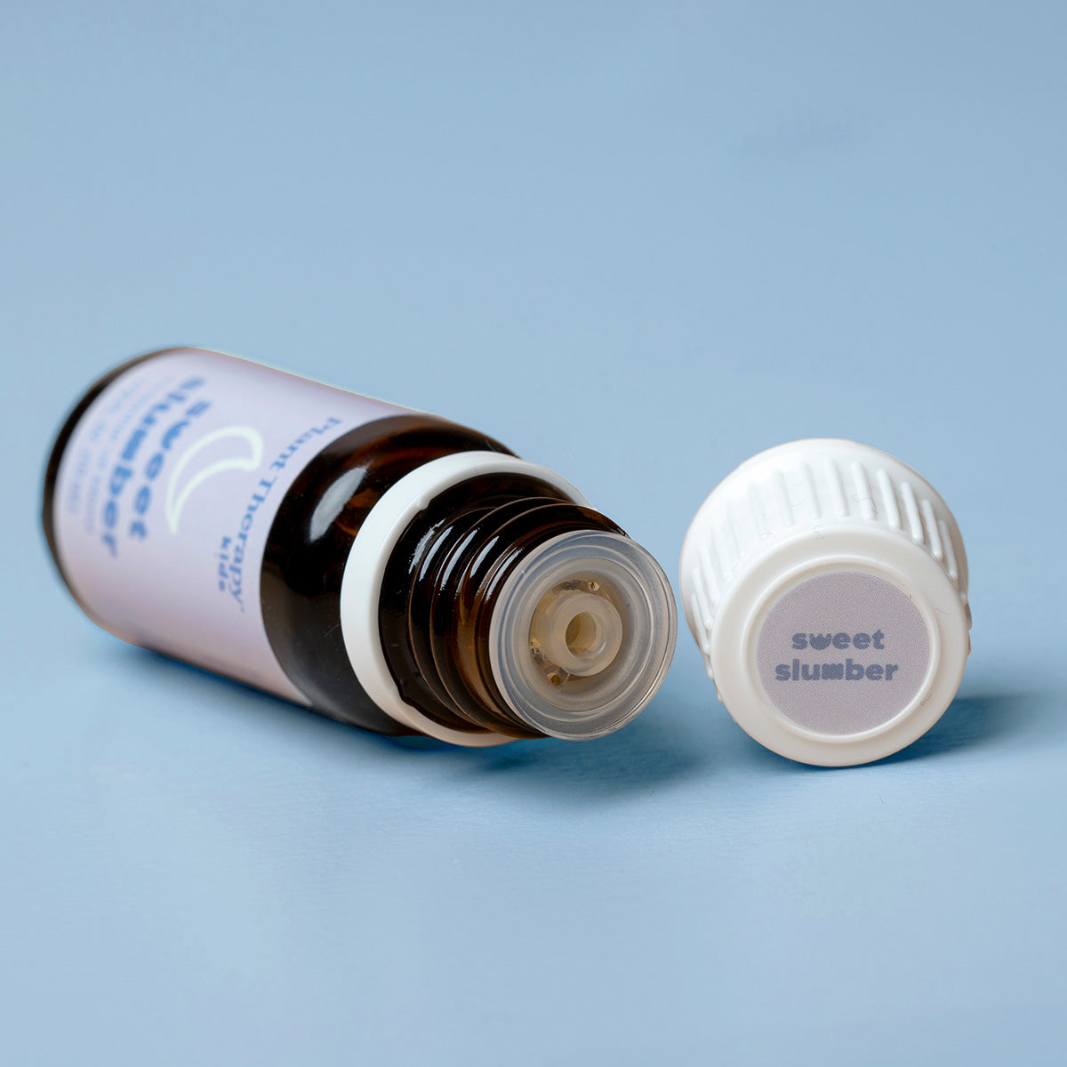 Open bottle of 'sweet slumber' on a light blue background
