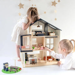 Lifestyle shot of child playing with Sweetwood Edge wooden dollhouse and miniature furniture
