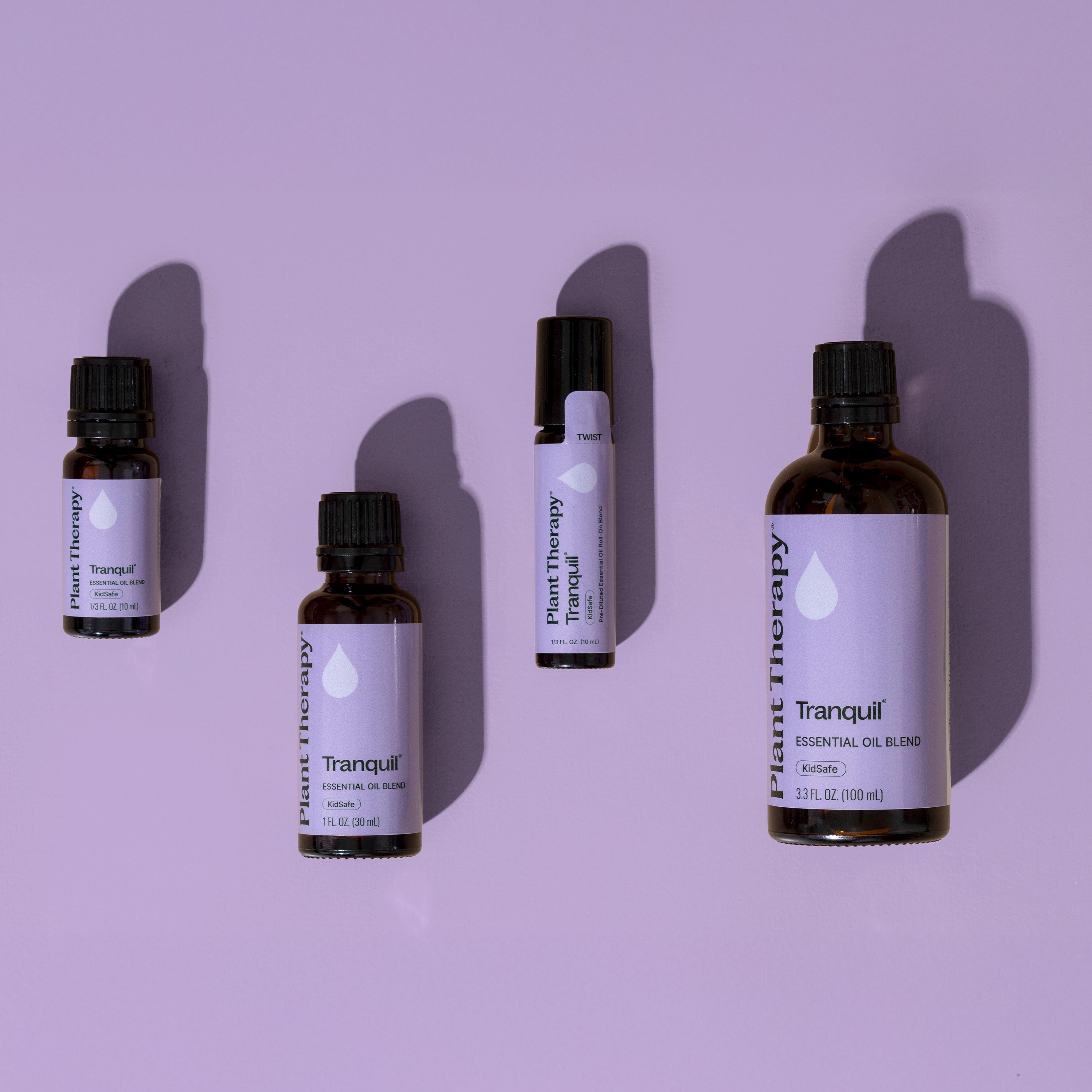 Collection of Plant Therapy Tranquil essential oil bottles on a purple background